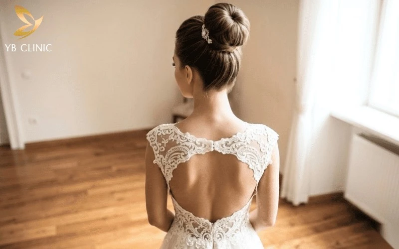 Vì Sao Nhiều Cô Dâu Chọn Búi Tóc Thay Vì Xõa? Điều Ít Người Để Ý 9 Tóc búi cao khoe khéo thiết kế hở lưng quyến rũ của váy cưới.